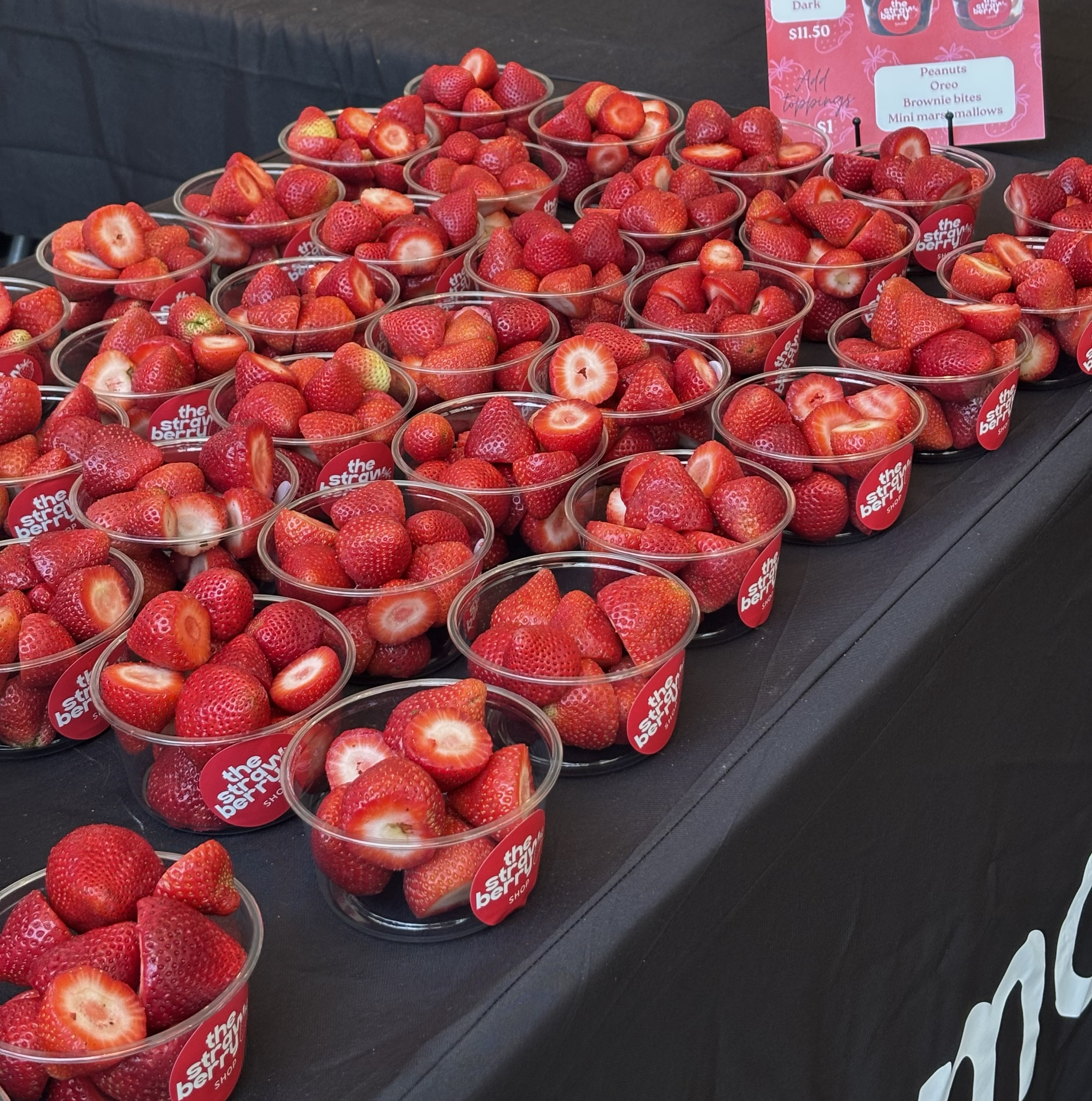 Strawberry cups displayed on a table at a catering event